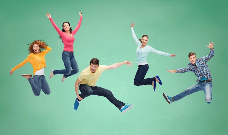 Fotografie happiness, freedom, friendship, education and people concept - group of smiling teenagers jumping in air over green board background