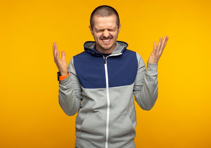 Fotografie happy laughting emotional man weared in hoodie at orange background