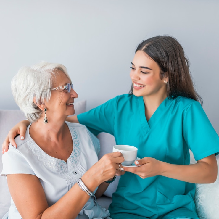 Fotografie happy senior woman talking with friendly nurse at geriatric ward