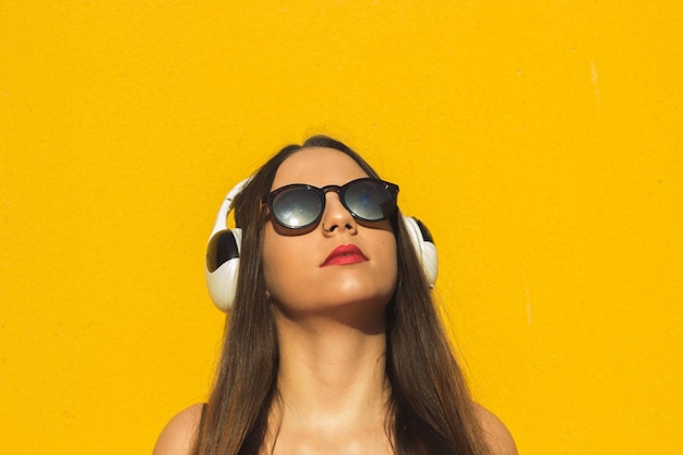 Head shot of a model listening music in headphones