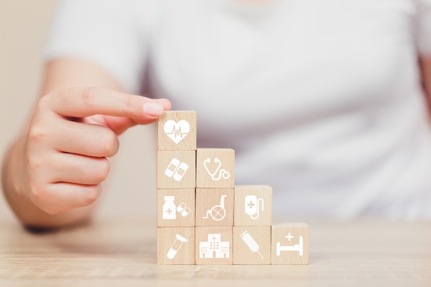 Health Insurance Concept,  hand arranging wood block stacking with icon healthcare medical