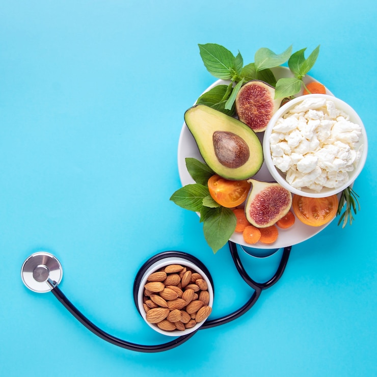 Fotografie healthy balanced nutrition concept. food in a plate and a stethoscope on a blue wall, top view.