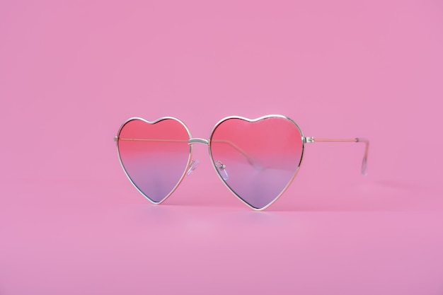 heart shape sunglasses against pink background