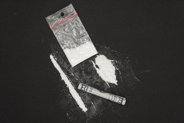 Fotografie heroin or other illegal drugs, white powder on a black background.