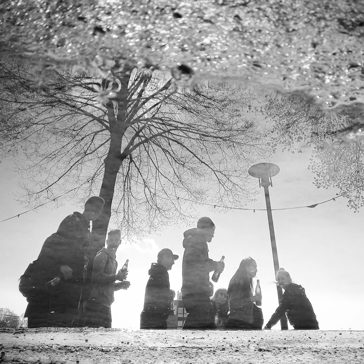 Fotografie high angle view of friends reflecting on puddle over street