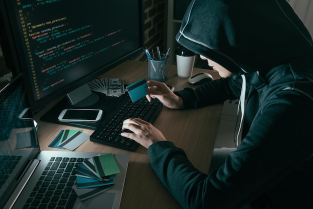 high angle view photo of hacker using computer online system stolen brushing credit card.