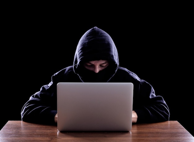 Hooded computer hacker stealing information
