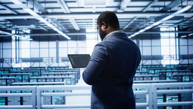 IT expert in server hub facility looking for network bugs with tablet