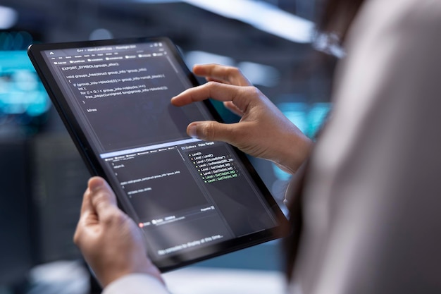 IT professional in server farm repairing infrastructure with tablet close up