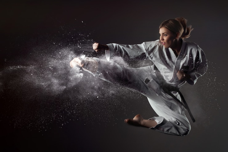 Fotografie karate girl bounces and makes a kick