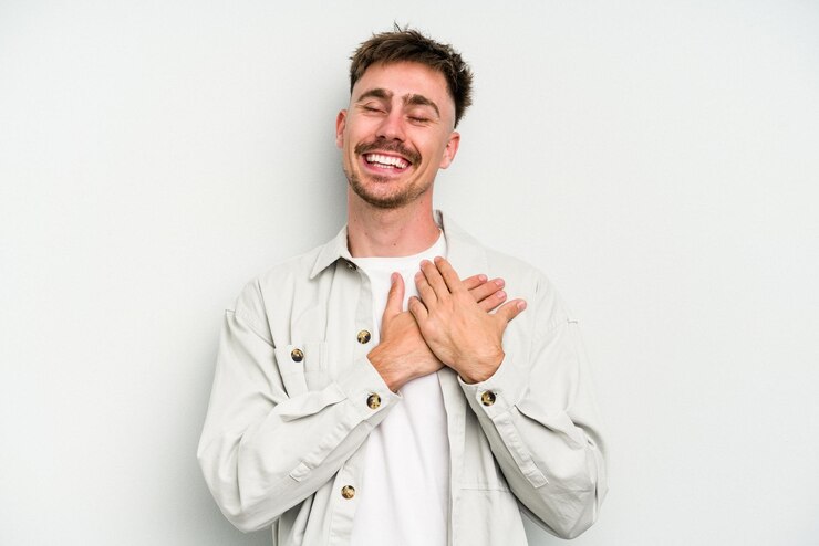 Fotografie laughing keeping hands on heart concept of happiness