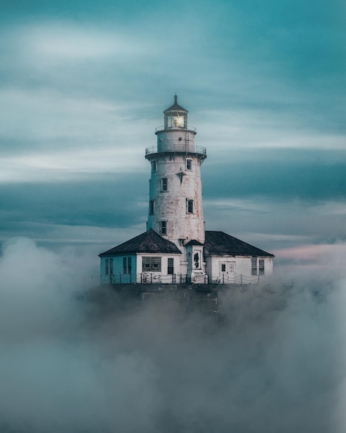 lighthouse against sky during foggy weather