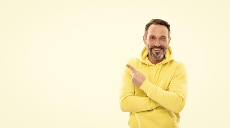 Fotografie look here adult guy advertising male casual sporty fashion copy space happy man pointing finger