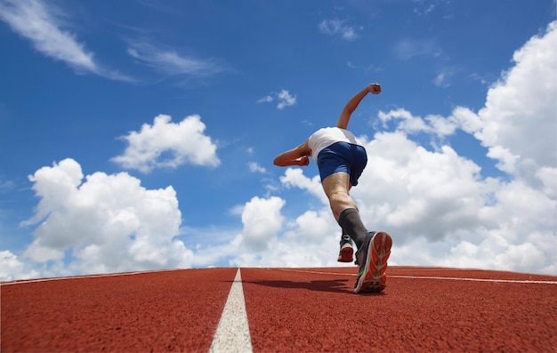 Low angle view of man running against blue sky
