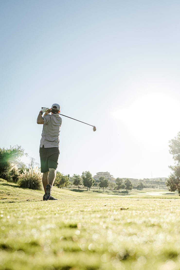Fotografie man hitting golf ball swinging and playing golf