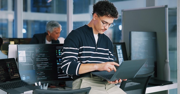Man programmer and office with laptop for coding software development or app design Male person coder or developer with computer or technology for cybersecurity web or IT services at workplace