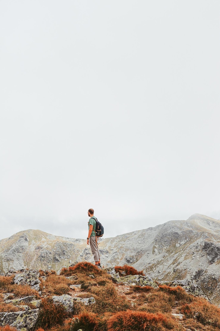 Fotografie man standing on rock against sky