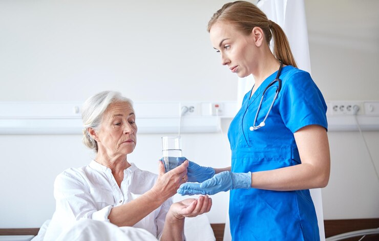 Fotografie medicine, age, health care and people concept - nurse giving medication and glass of water to senior woman at hospital ward