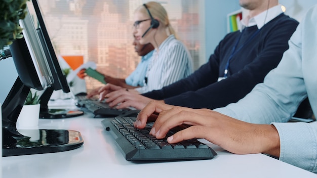 medium shot of operators hands typing on keyboard in modern office