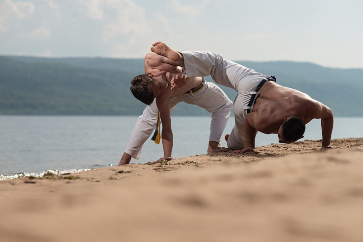 Fotografie men train capoeira on the beach - concept about people, lifestyle and sport.