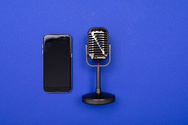 Minimalism concept. phone and microphone on a bright blue background 