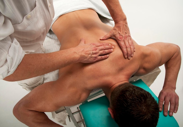 Fotografie muscular man at the massager