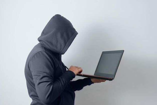 mysterious man wearing hoodie holding laptop