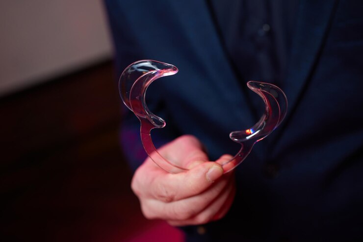 Fotografie nurse holding a dental retractor in her hands. dental cheek retractor close-up in hands. lip retractors.