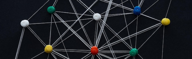 panoramic shot of push pins connected with strings isolated on black network concept