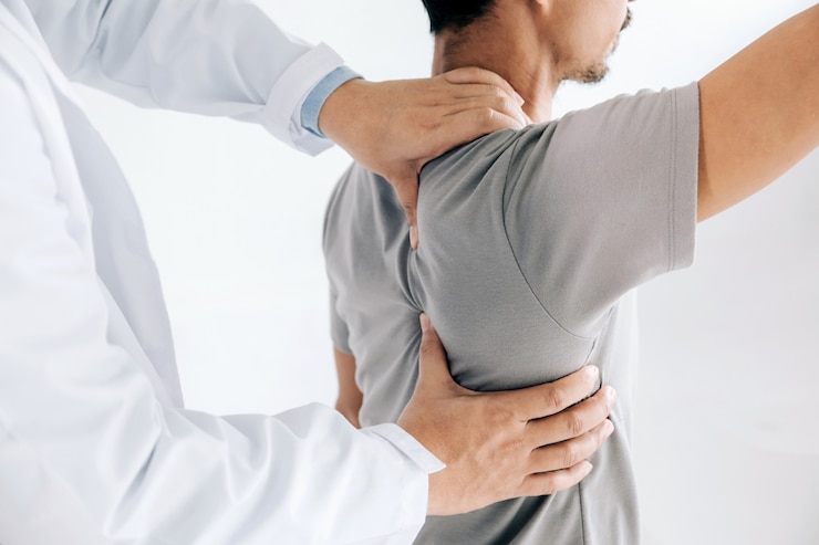 Fotografie physiotherapist doing healing treatment on man's back. back pain patient,  treatment