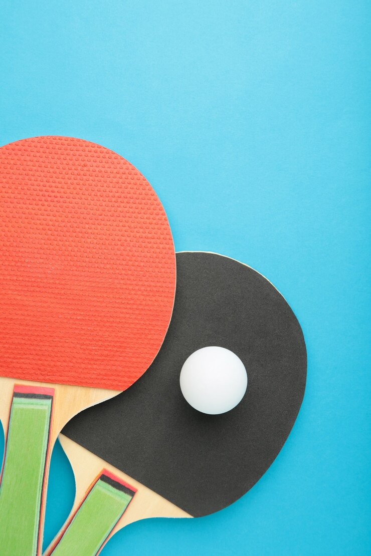 Fotografie ping pong rackets and ball on blue background. top view