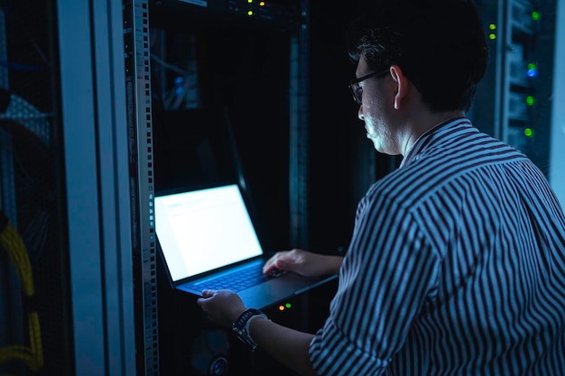 Počítačový inženýr nastavuje síť v serverovně. Technik údržby systémů. Inženýr pracuje v serverovně v moderním datovém centru.