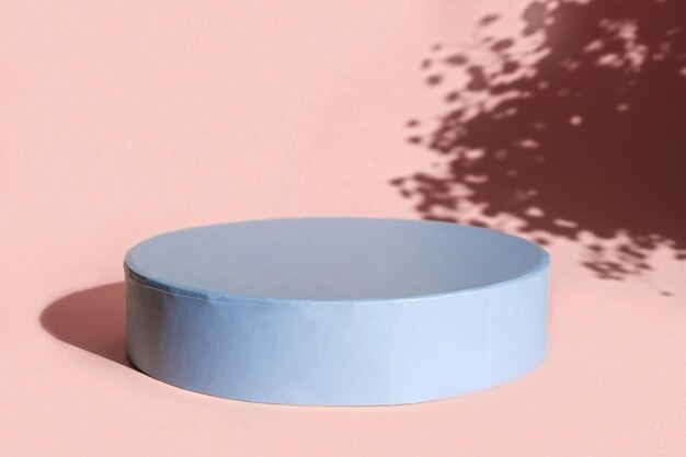 podium for cosmetic product presentation. abstract minimal form with geometrical form. cylinder podium with floral sunlight shadow. scene to show products. showcase, display case. flat lay, top view.