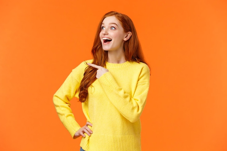 Fotografie portrait of a beautiful young woman against orange background