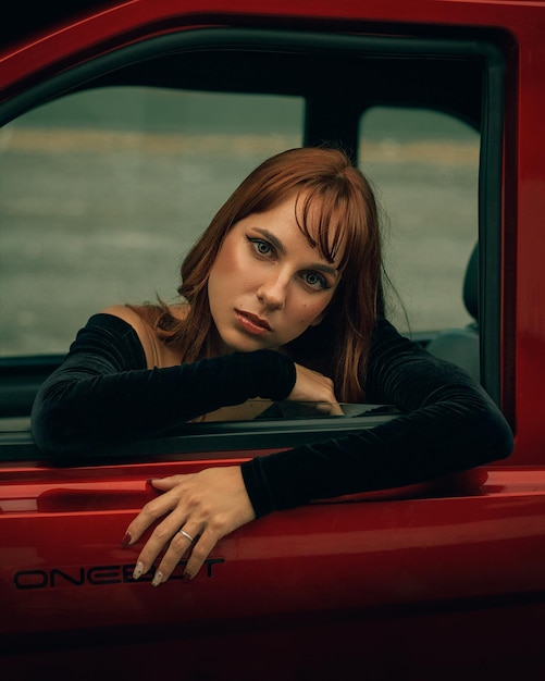 portrait of a beautiful young woman sitting in car and looking at the camera with a penetrating gaze