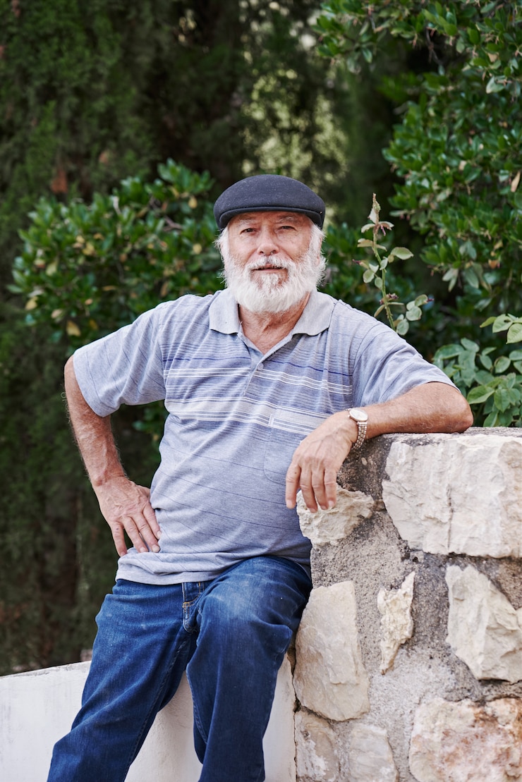 Fotografie portrait of a stylish older man wearing a beret on a green background