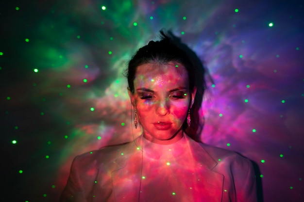 Portrait of beautiful woman standing against illuminated light