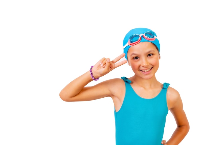 Fotografie portrait of girl with swimsuit and diving goggles for swimming lessons in the pool making the victory symbol white background
