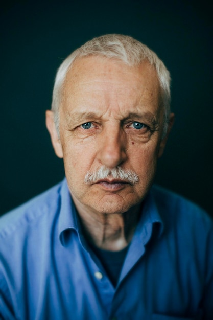 portrait of senior man against black background