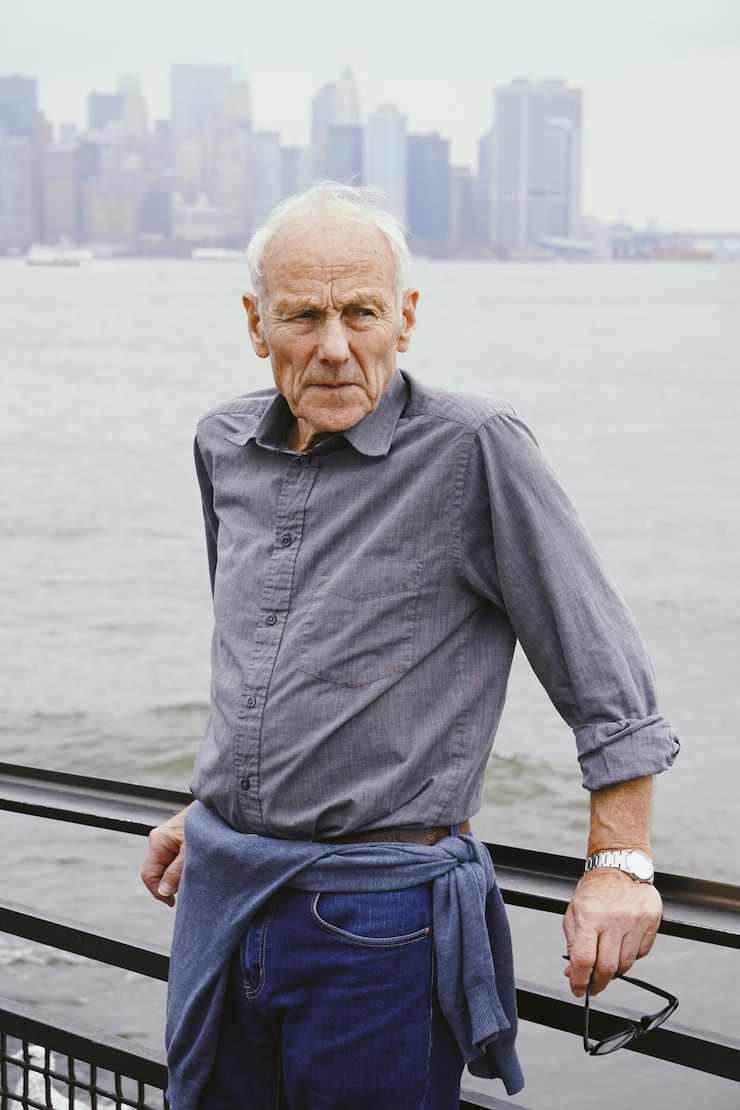 Fotografie portrait of senior man standing by river against sky in city