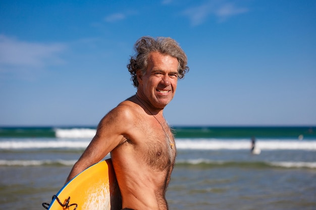 portrait of shirtless man at beach against sky