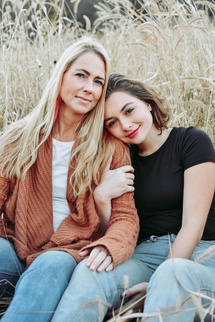Fotografie portrait of smiling women sitting on land against plants