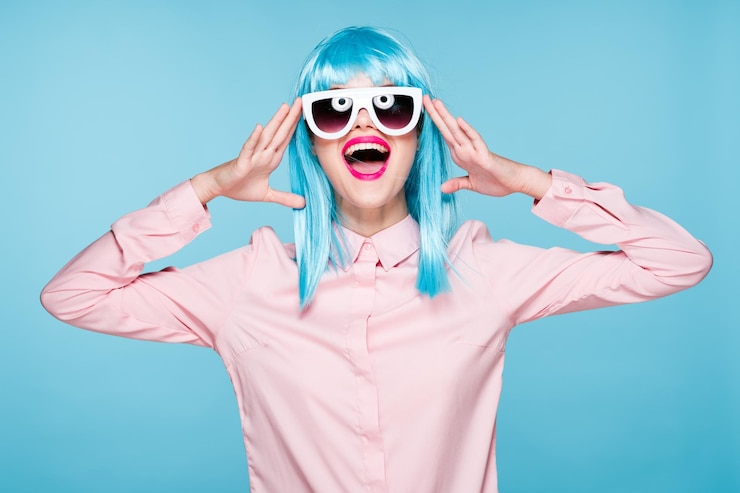 Fotografie portrait of woman wearing sunglasses against blue background