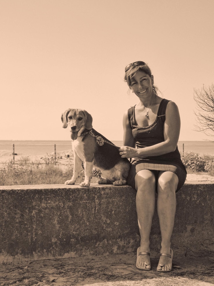 Fotografie portrait of woman with dog sitting on retaining wall against clear sky