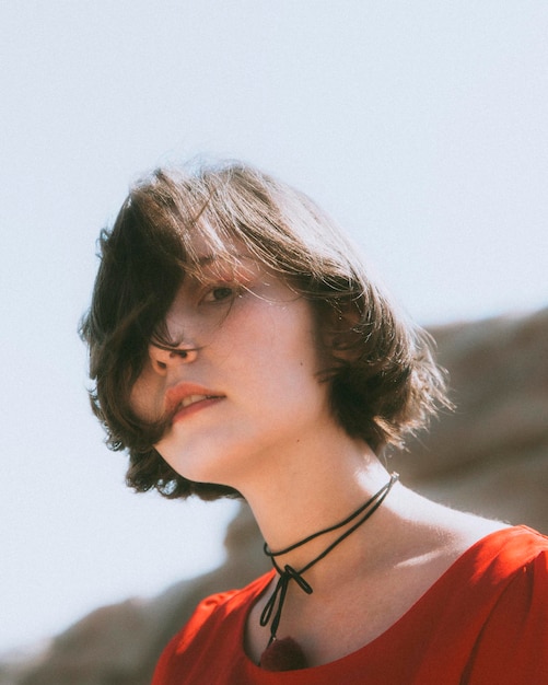 portrait of young woman at beach against sky