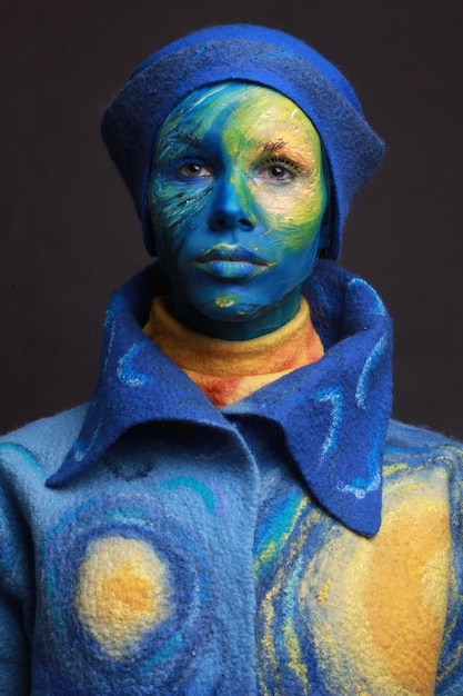 portrait of young woman with painted face against black background