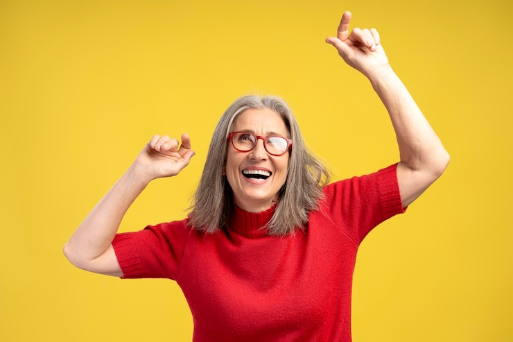 Fotografie portrait smiling senior woman wearing stylish eyeglasses and red sweater dancing