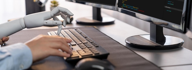 Program coding automation by generative artificial intelligence or AI concept Collaboration between robotic hand and human software developer solving debugging or writing scriptTrailblazing