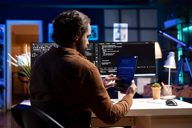Programmer using tablet to fix vulnerabilities compromising systems