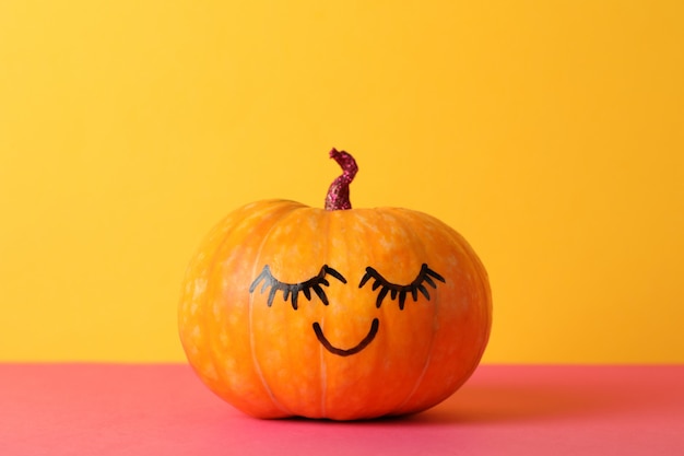 pumpkin with smile against yellow, space for text